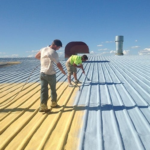 Contractors work on metal roof coating.