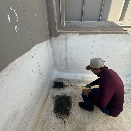 Roofer inspects damaged commercial roof.