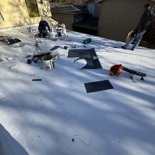 Contractors work on single ply roofing.