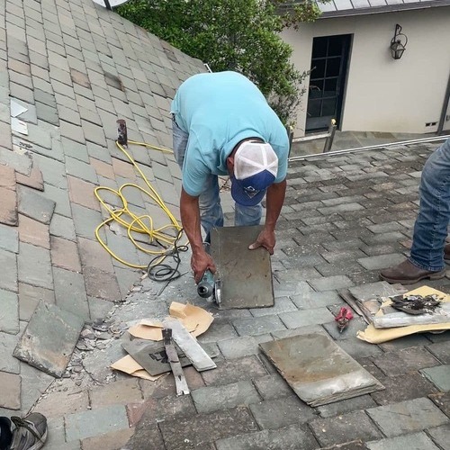 Roofer replaces slate roofing