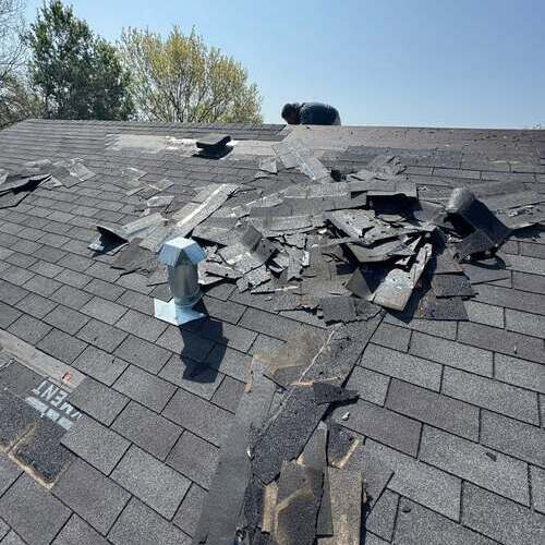 Roofer works on storm damage.